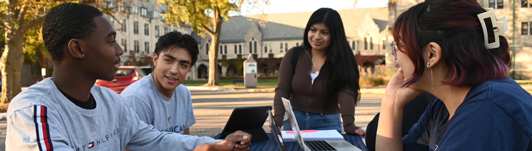 Four students at table outside