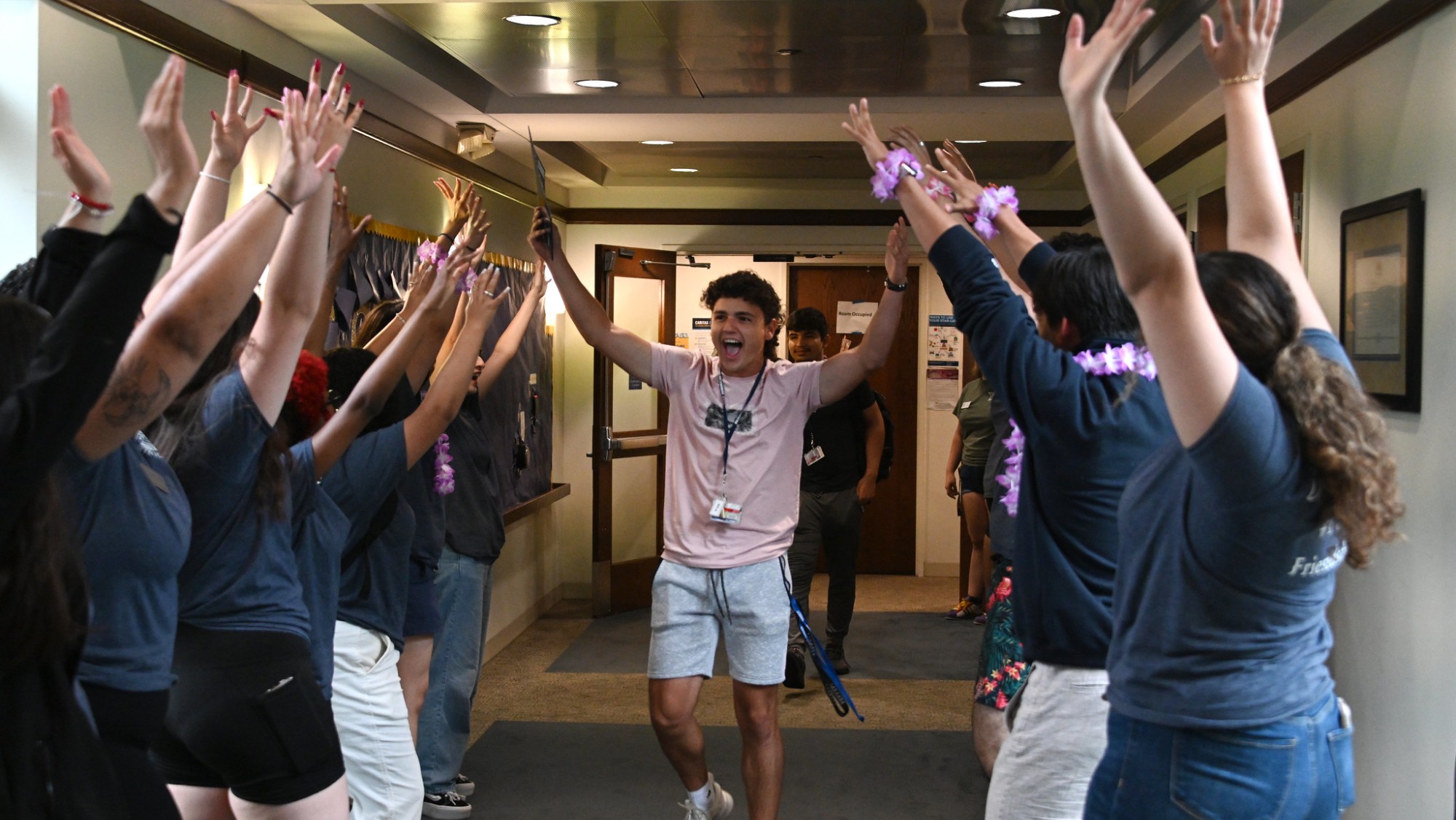 Student moving through a grpooup of students in the hall