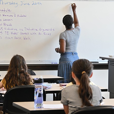 Teacher at blackboard with young students