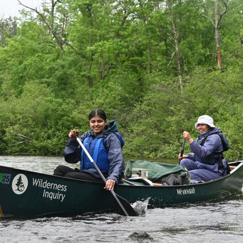 Two student in rowboat on the river