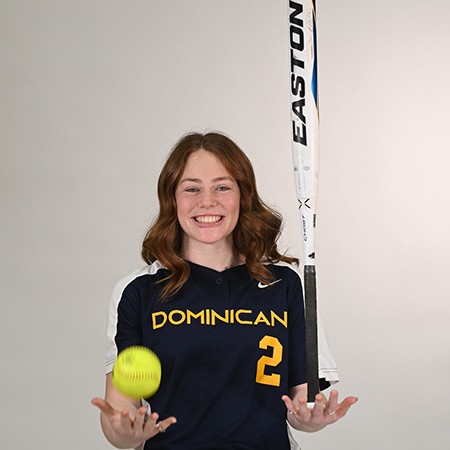 Softball player holding ball and bat