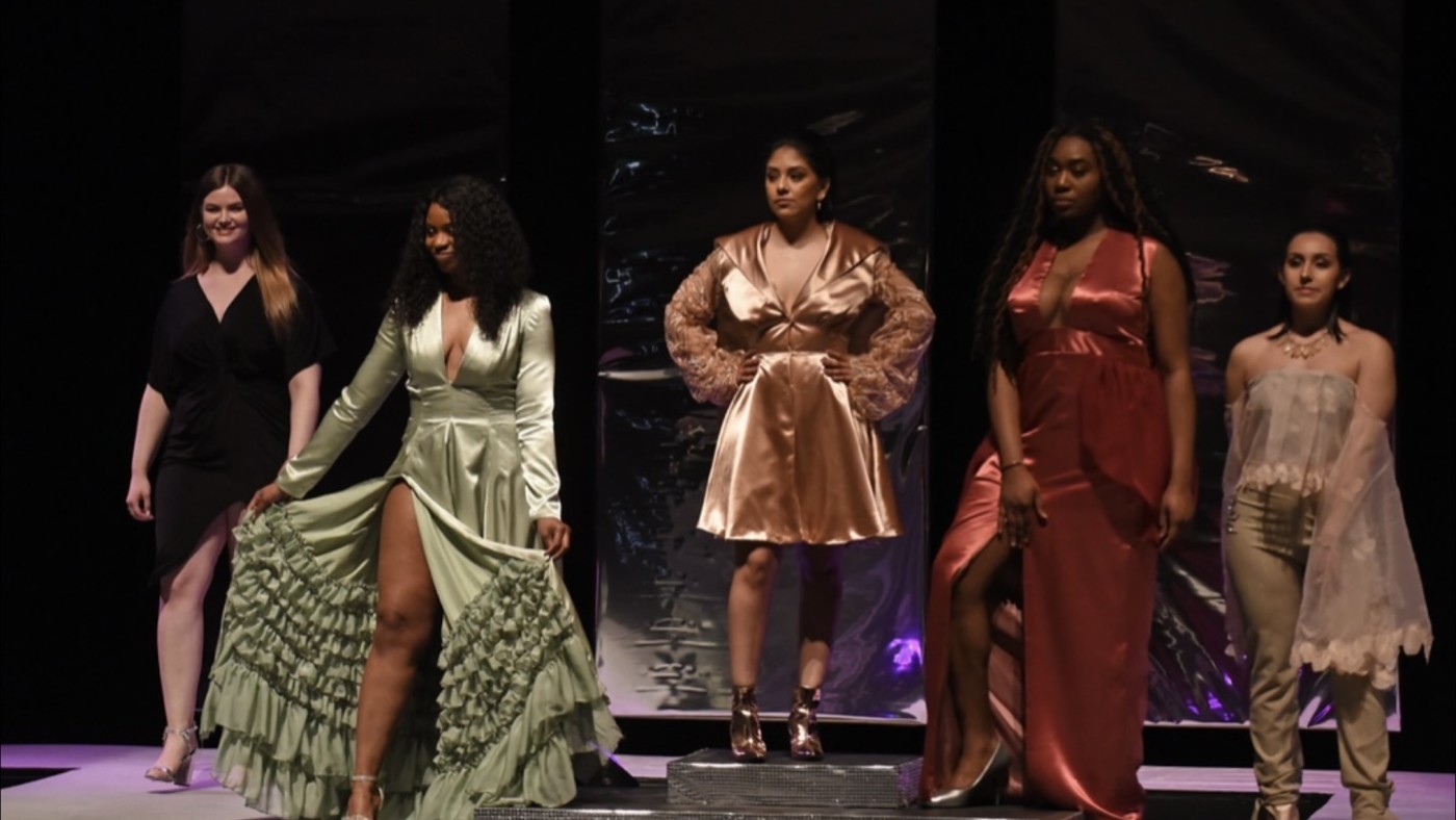 Models on stage wearing outfits designed by students at Dominican University's Annual Fashion Show