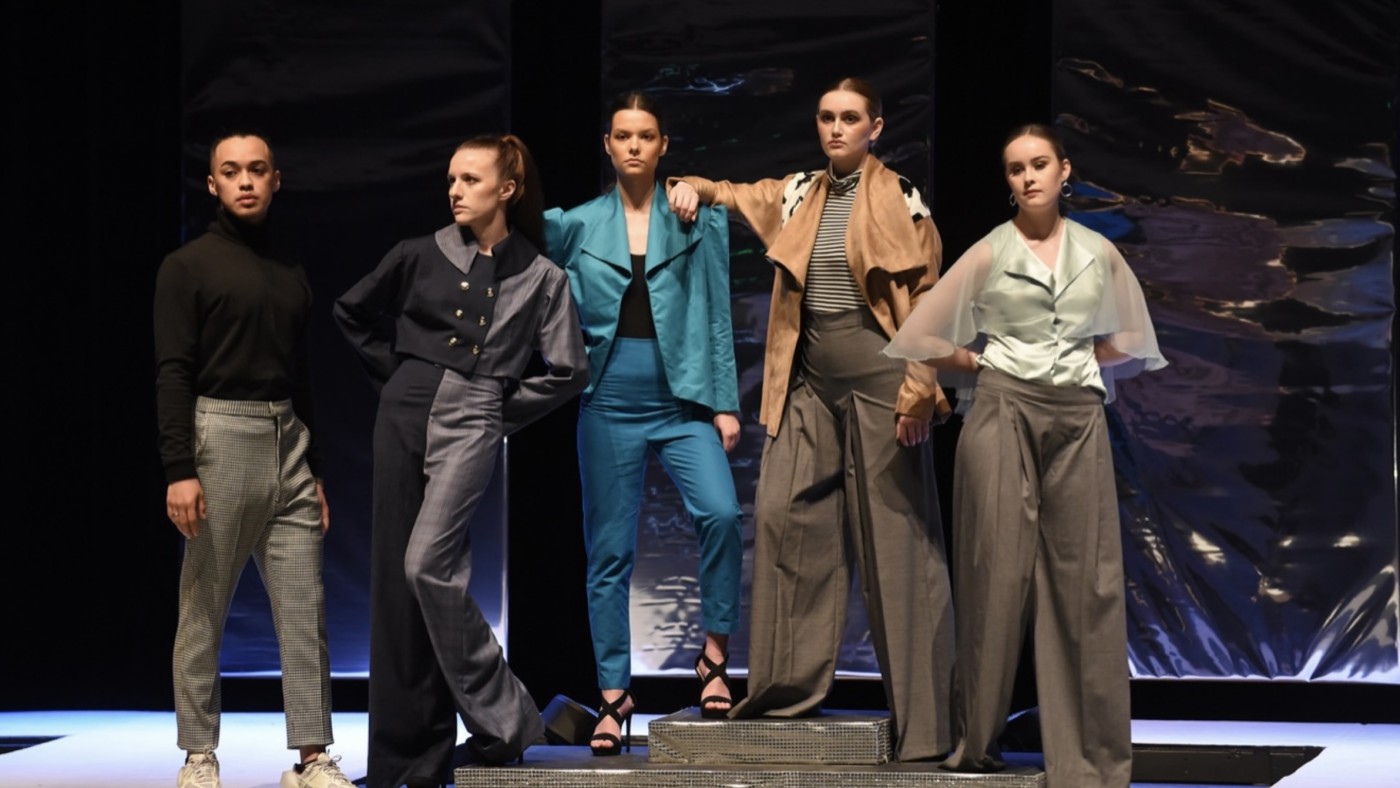 Models on stage wearing outfits designed by students at Dominican University's Annual Fashion Show