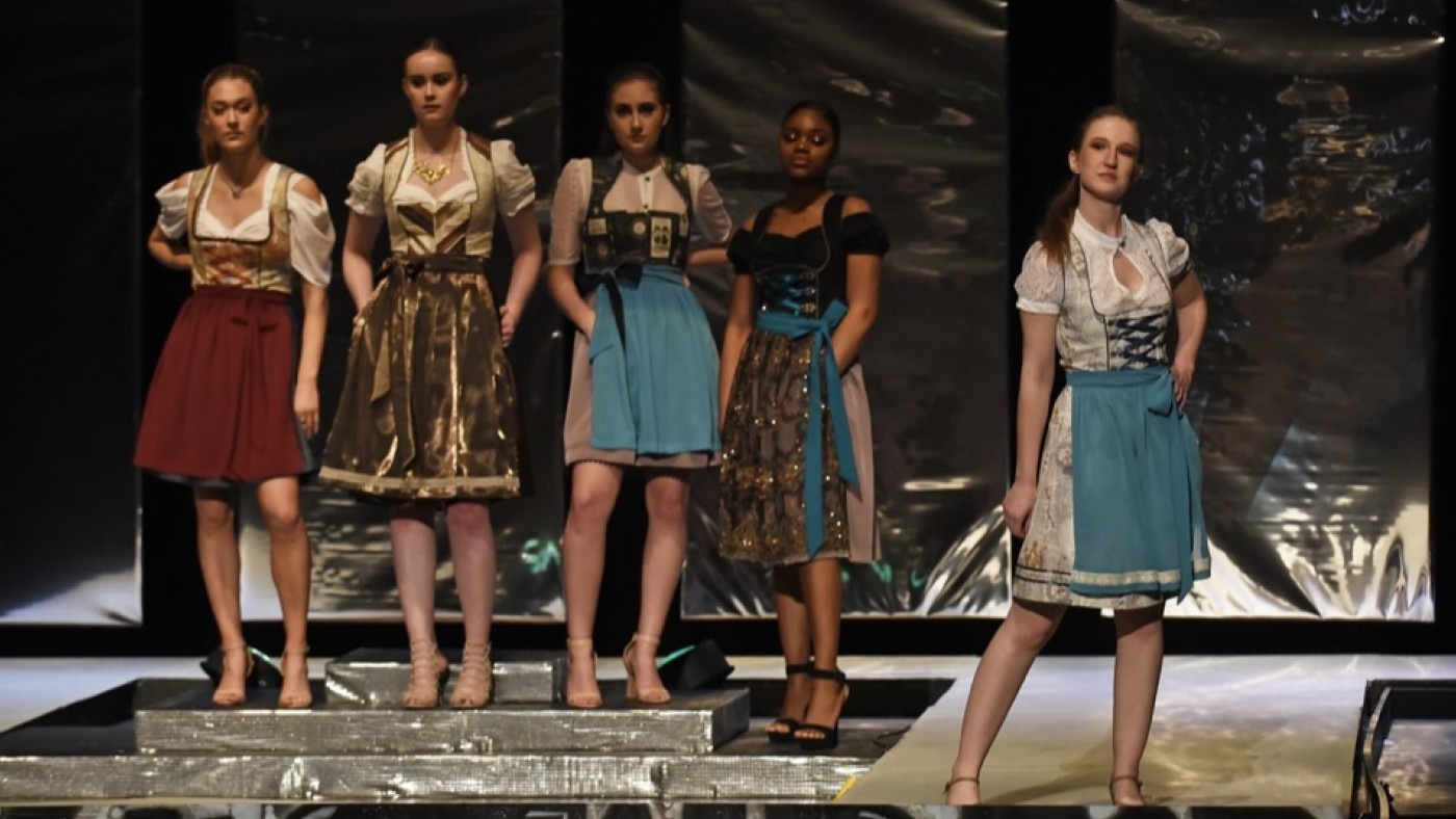 Models on stage wearing outfits designed by students at Dominican University's Annual Fashion Show