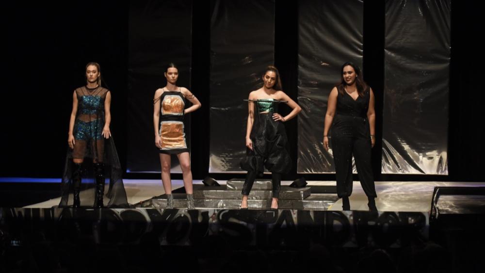 Models on stage wearing outfits designed by students at Dominican University's Annual Fashion Show