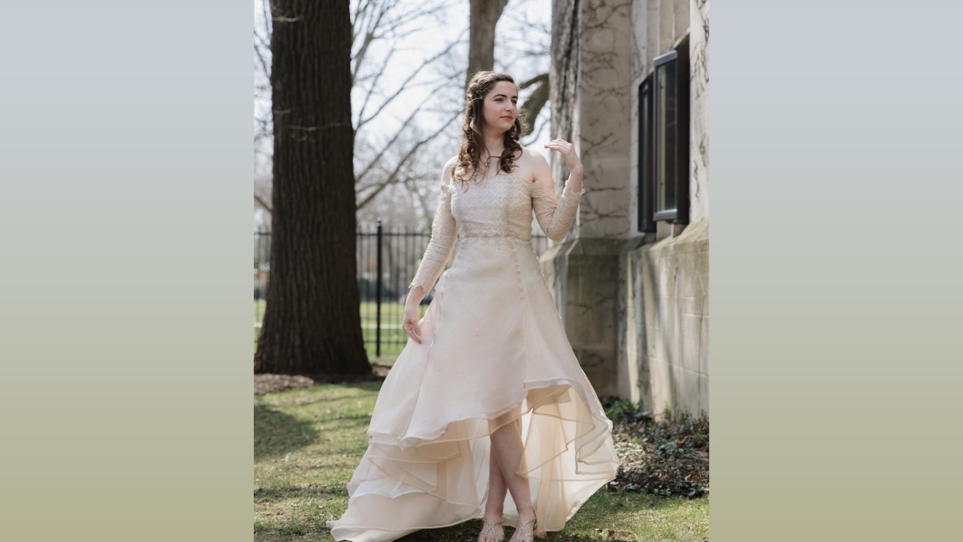 Model wearing outfit designed by student walking on stage at Dominican University's Annual Fashion Show