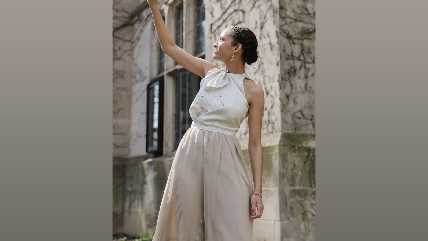 Model wearing outfit designed by student walking on stage at Dominican University's Annual Fashion Show