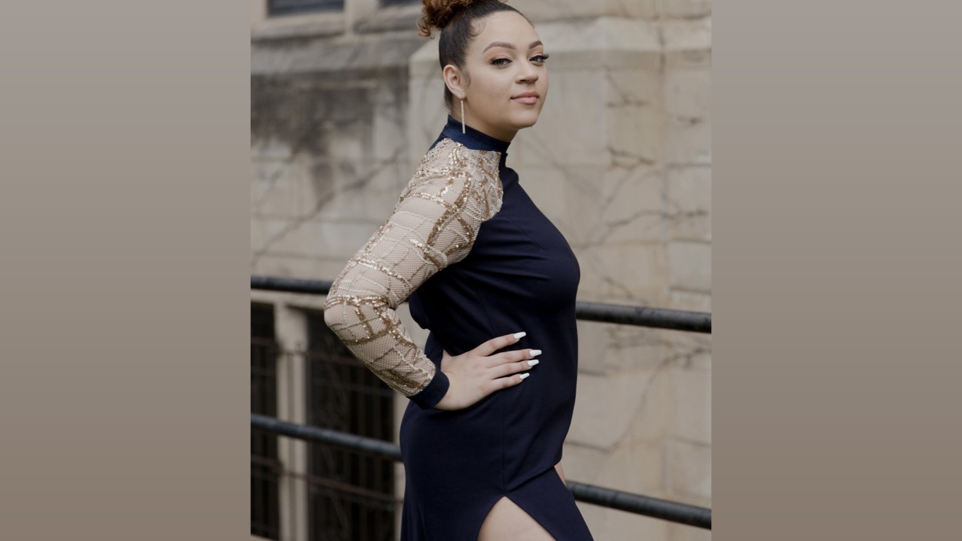 Model wearing outfit designed by student walking on stage at Dominican University's Annual Fashion Show