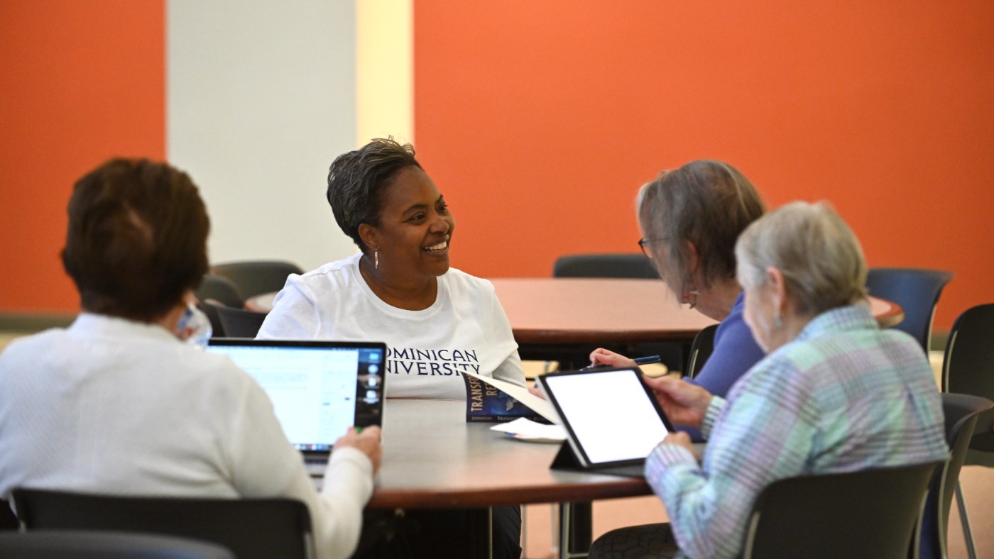 Regina Alexander (center) at table with students