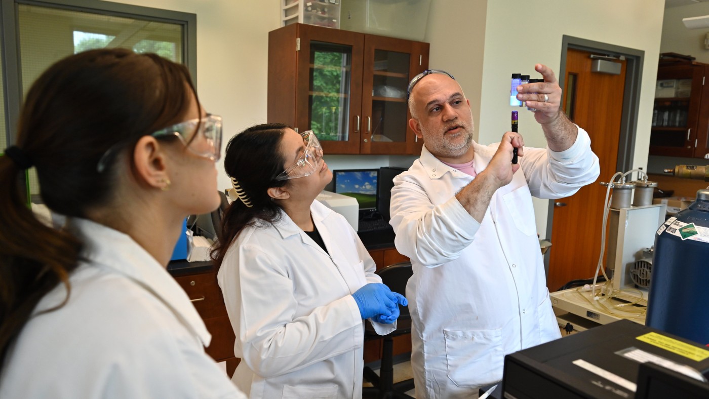 Chemistry profession with two students in lab