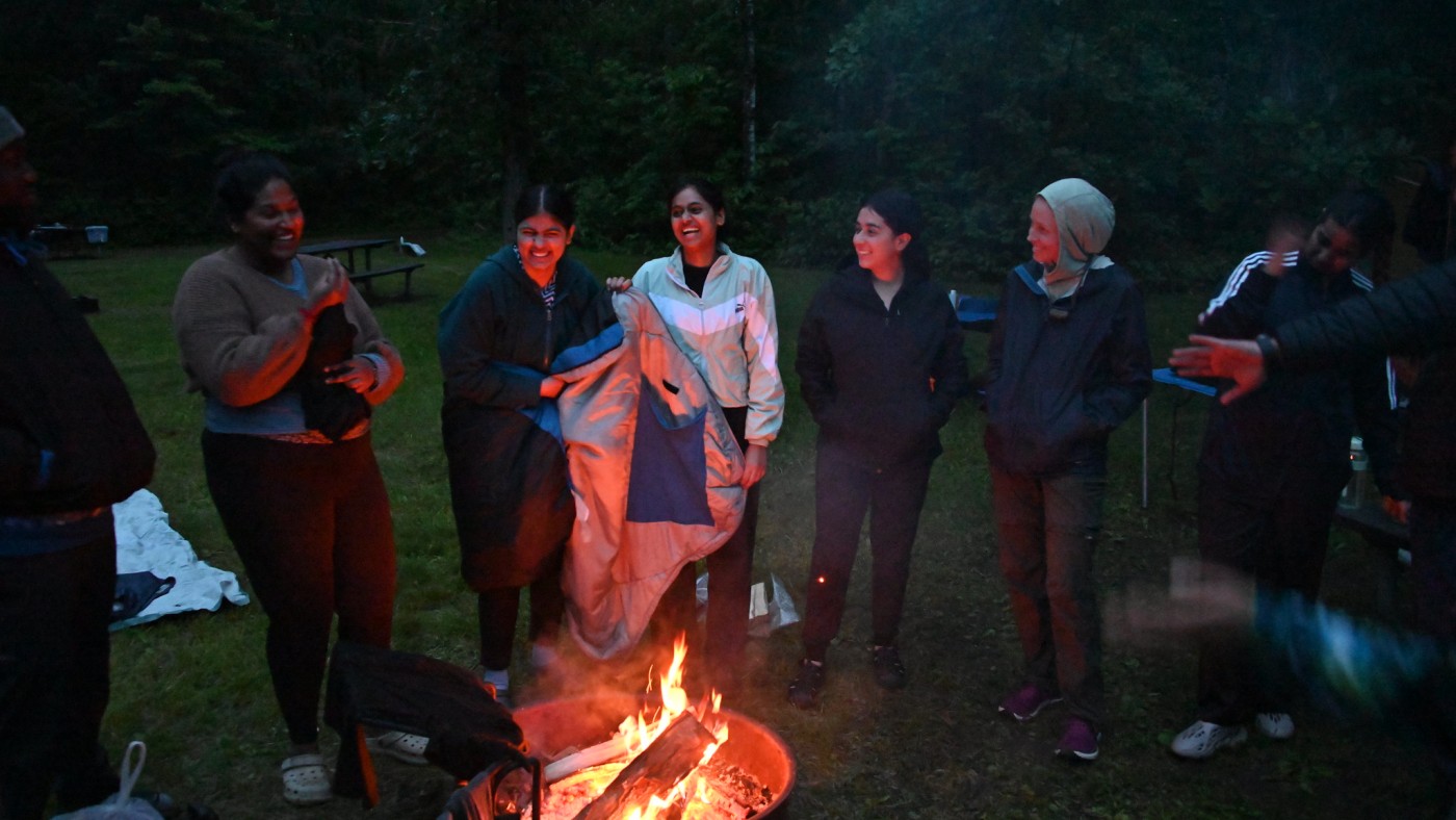 Several students around a campfire