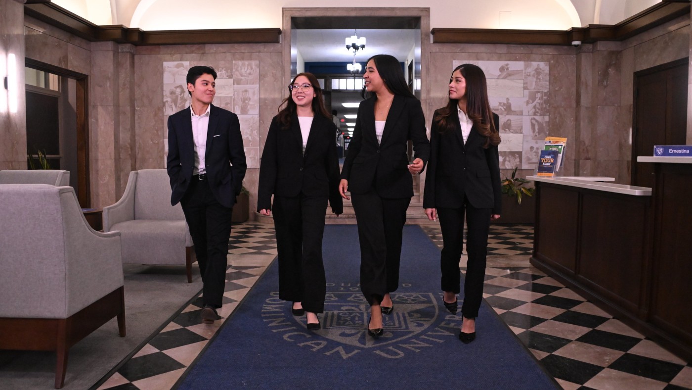 Four professional dressed students in the Welcome Center