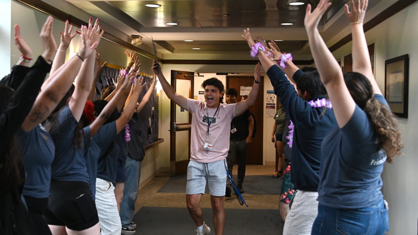 Student moving through a grpooup of students in the hall