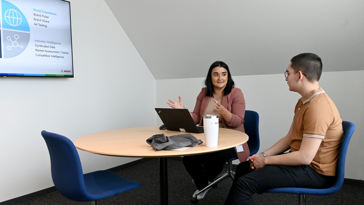Two individuals at table with laptops