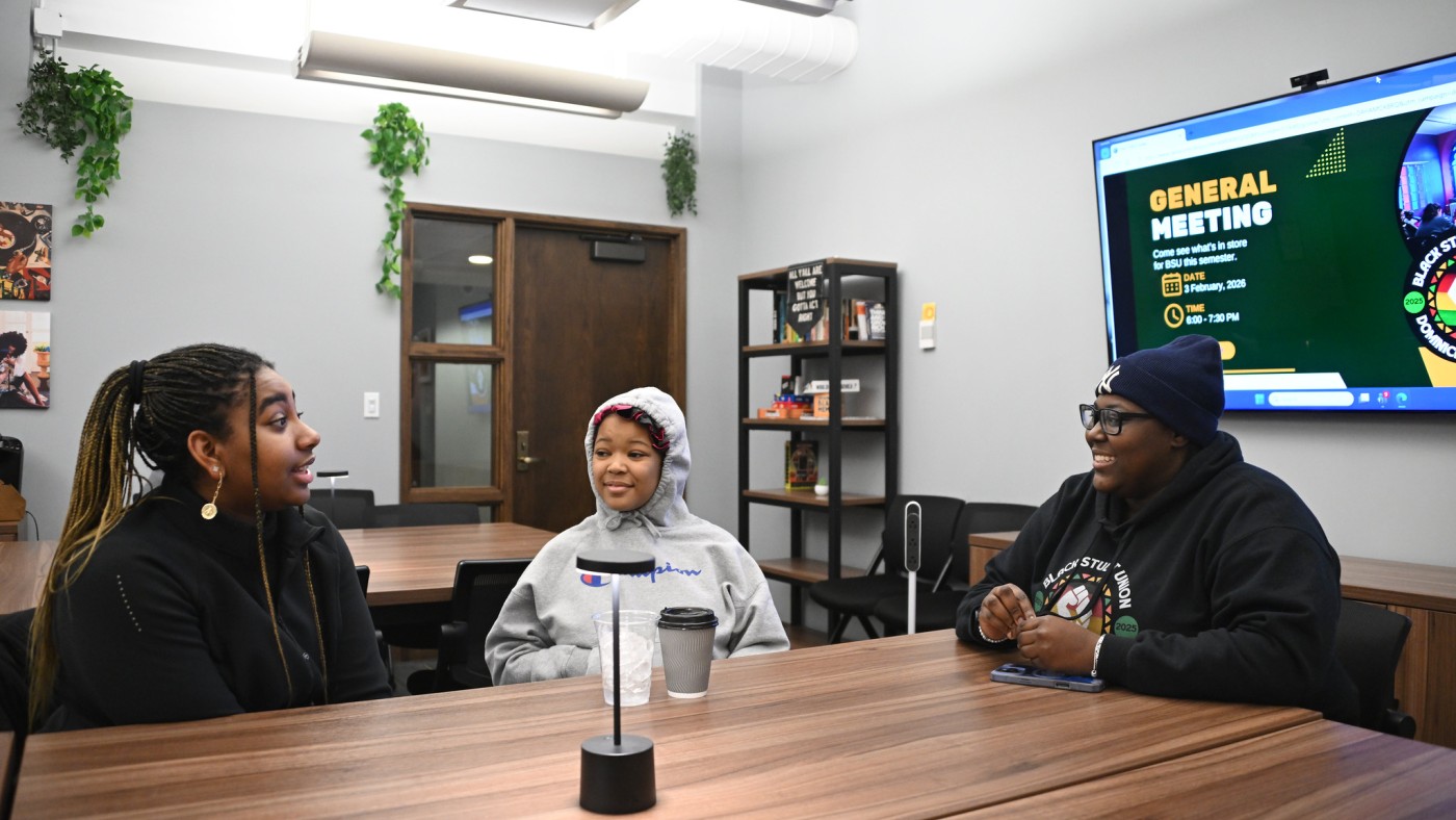 Three students seated at a table in the Bowman Center