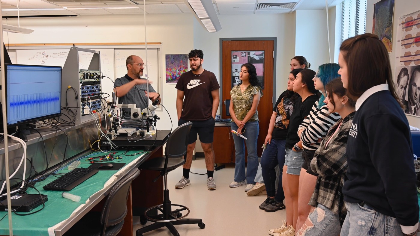 A professor talks to students in the neuroscience lab.