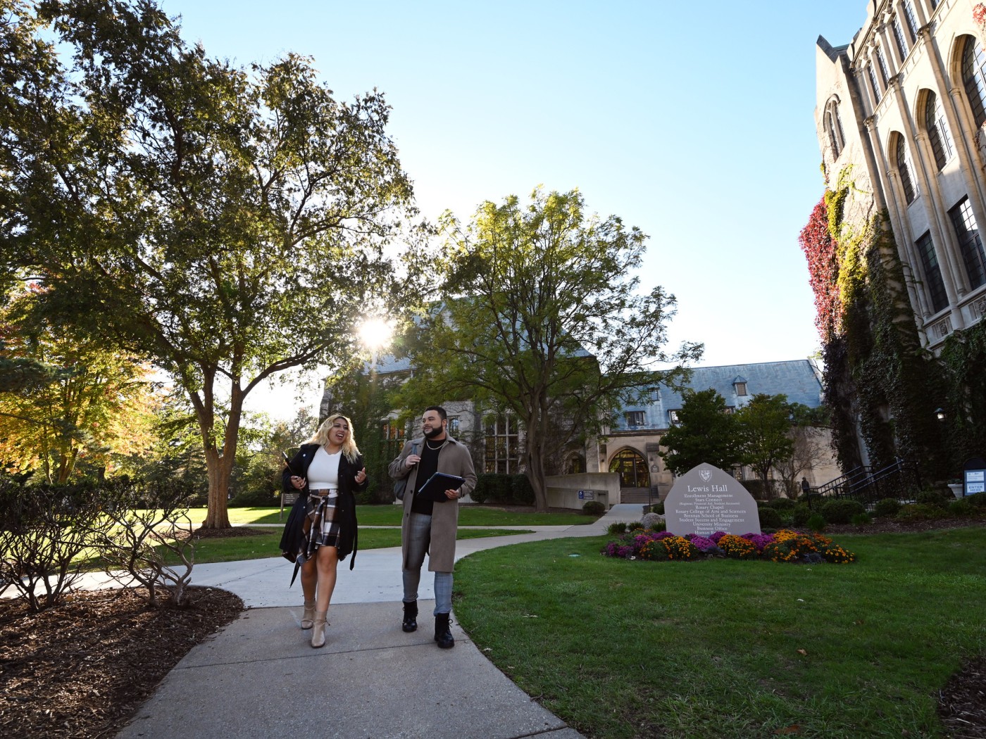 Male and female student walking outdoors on campus