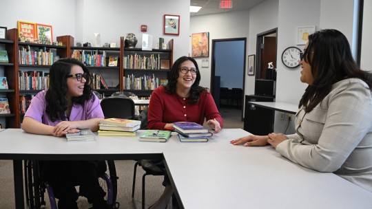 Three female students at a work table